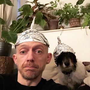 With a dog, both wearing foil hats
