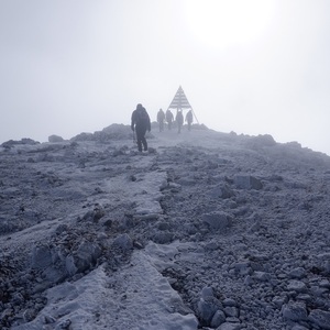Walkers approaching a snowy summit